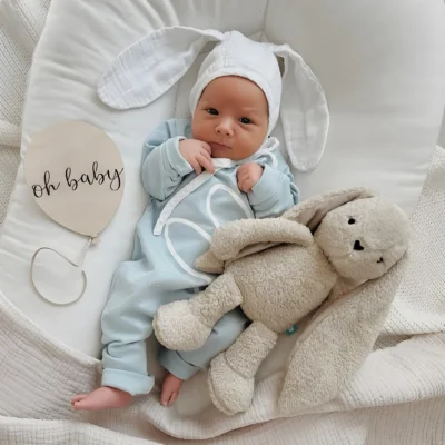 Un bebé tranquilo y feliz abrazando su Conejito 5en1 con sonidos relajantes. El peluche más suave y adorable que acompaña sus sueños desde el primer día.